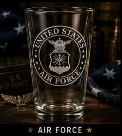 Clear glass with United States Air Force emblem on a wooden surface with American flags in the background