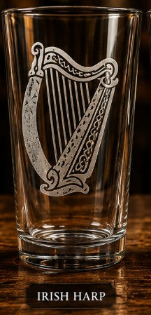 Clear glass with an engraved Irish harp design on a wooden surface.