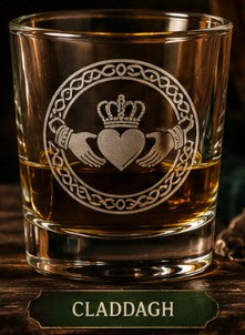 Glass with Claddagh design and claret inside, on a wooden surface.