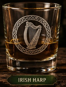 Glass with Irish harp design filled with whiskey on a wooden surface