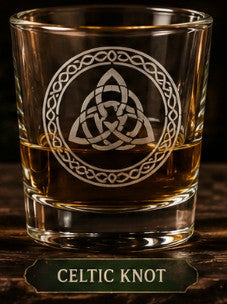 Glass with Celtic knot design filled with a liquid on a wooden surface