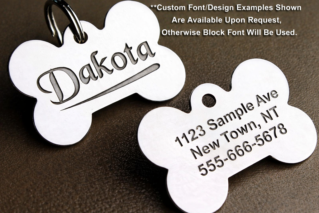 Two bone-shaped pet tags with engraved text on a brown background