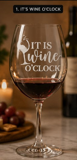 Wine glass with 'It is Wine O'clock' text on a table with grapes and a candle.