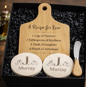 Personalized cutting board set with ceramic coasters and cheese knife in a gift box.